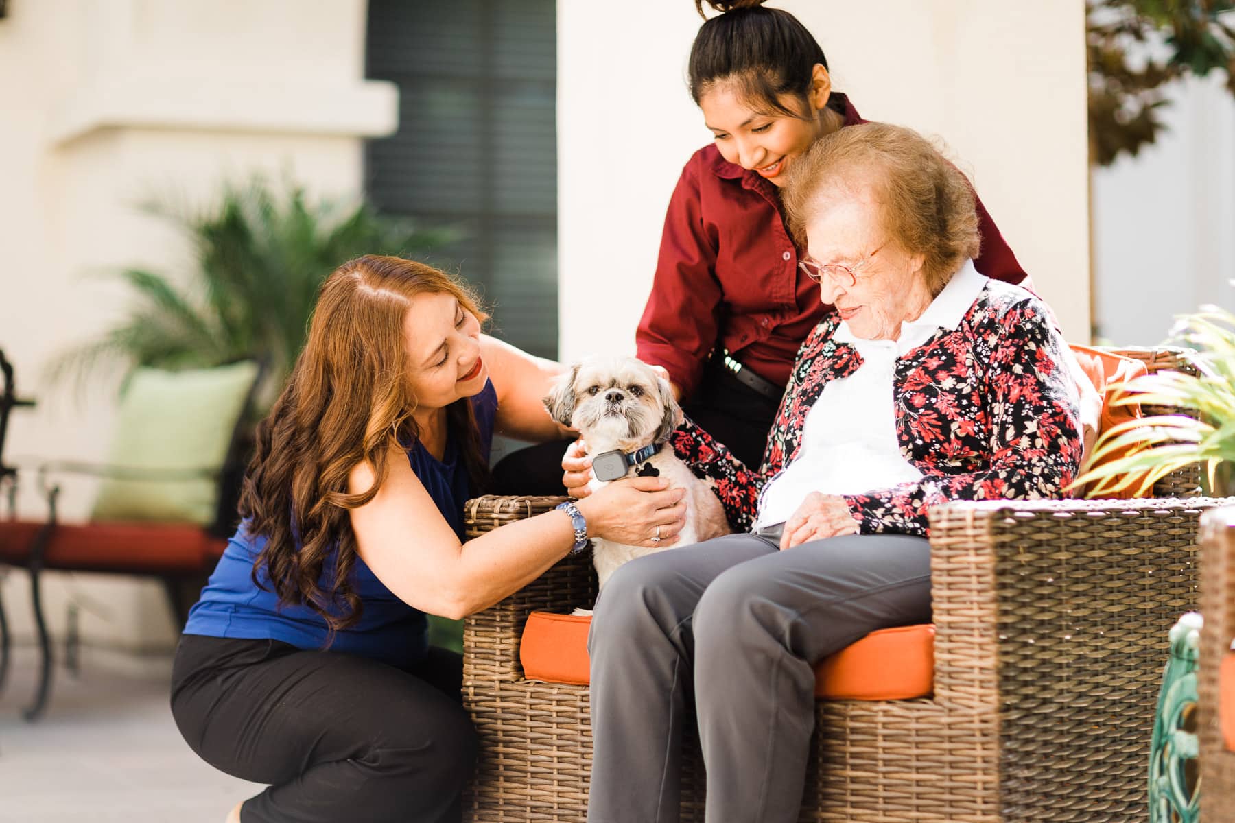 two caregivers and resident on couch with dog