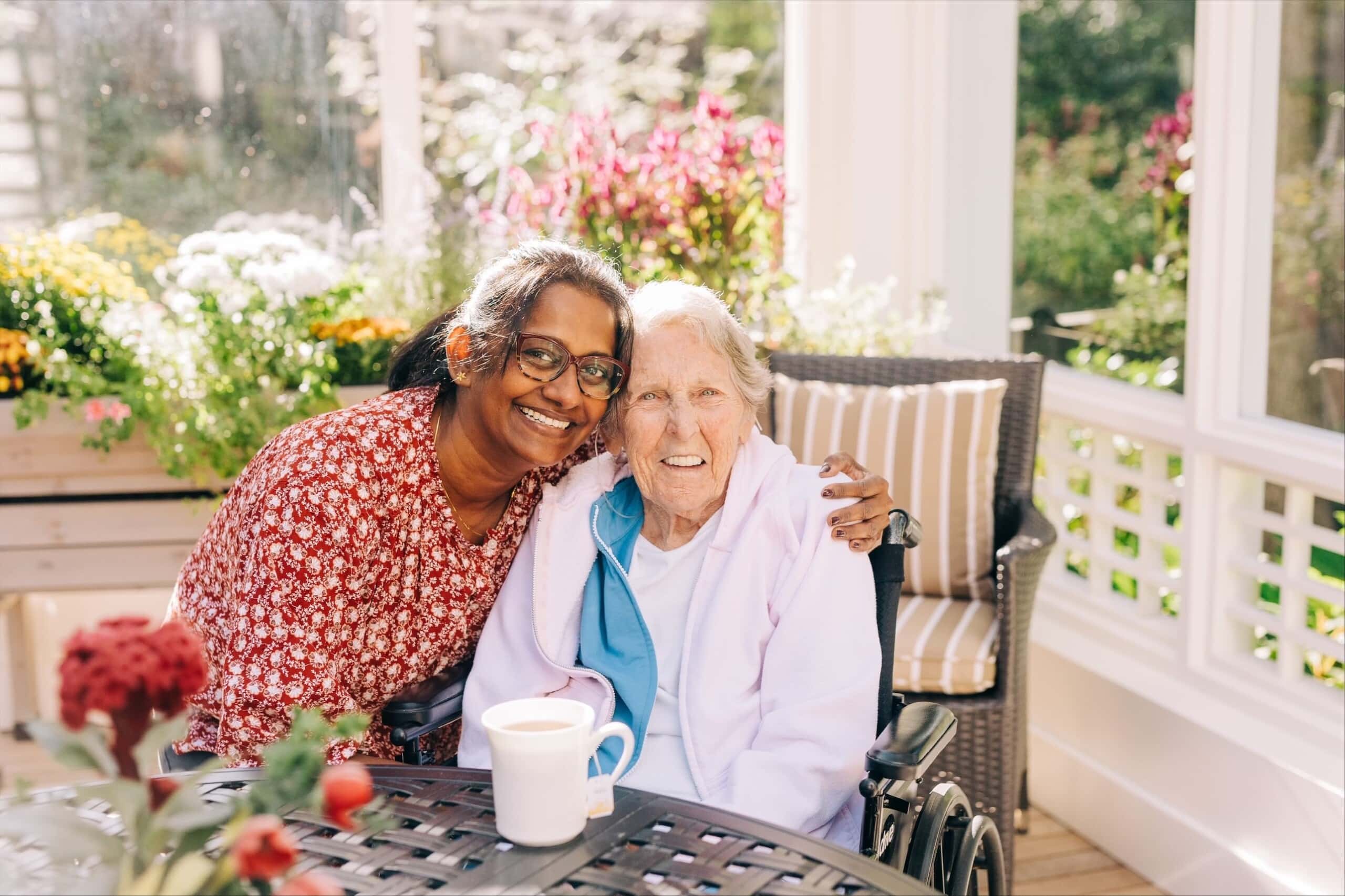 care partner and resident smiling in garden patio