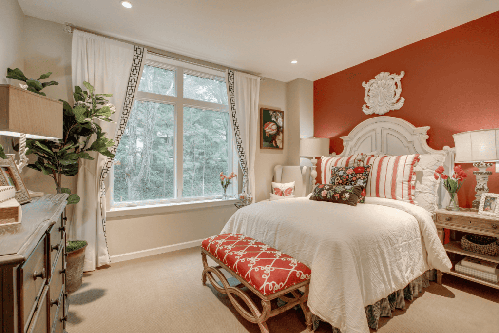 A bedroom with red accent walls and a bed.