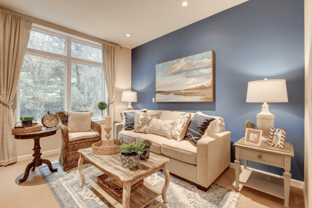 A bedroom with blue accent wall and a couch.