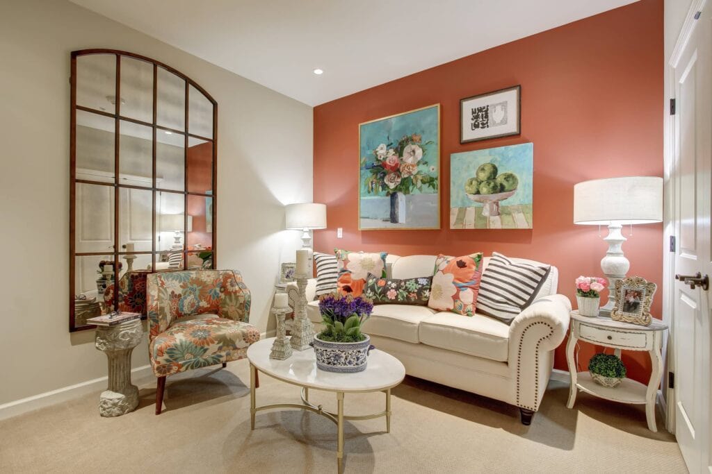 A living room with orange walls and white furniture.