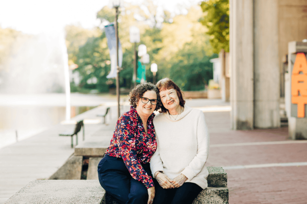 woman and elderly woman sitting on bench together