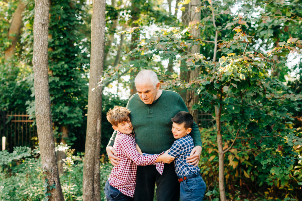 two young boys hugging older man family member