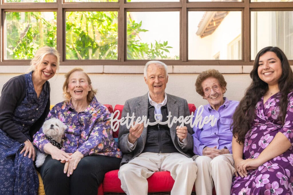 elderly and caregivers sitting on couch together
