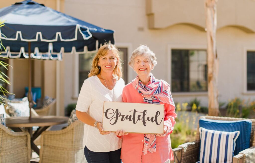 two ladies holding sign that says grateful