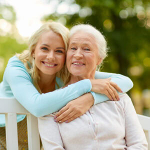 Daughter and older mother seating on a bench