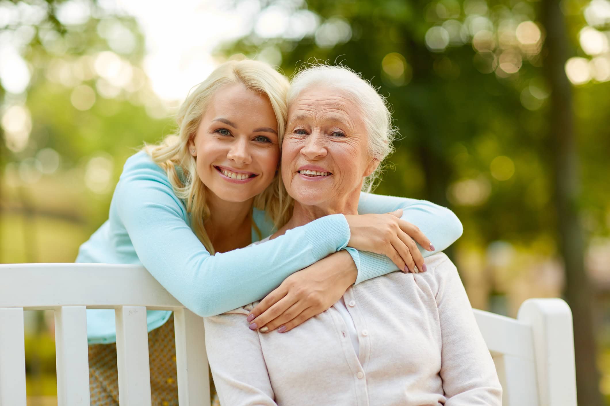 Daughter and older mother seating on a bench